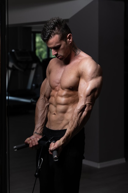 Homme exerçant des biceps dans la salle de gym