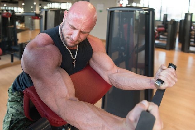 Photo homme exerçant des biceps dans la salle de gym