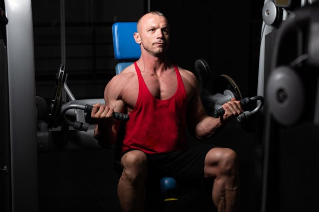 Homme exerçant des épaules dans la salle de gym