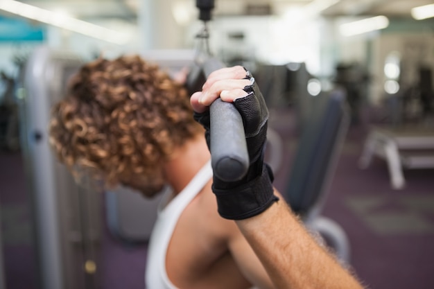 Homme exerce sur une machine de lat dans la salle de gym