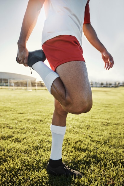 L'homme de l'exercice et l'athlète faisant des étirements se préparent à l'entraînement et s'entraînent pour le match de football avec entraînement en tenue de sport sur le terrain Football bien-être et homme en bonne santé prêt match fitness et échauffement