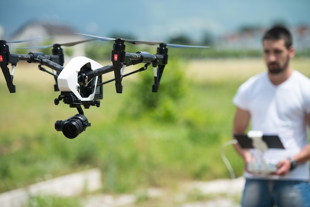 Homme exploitant un drone volant ou planant par télécommande dans la nature