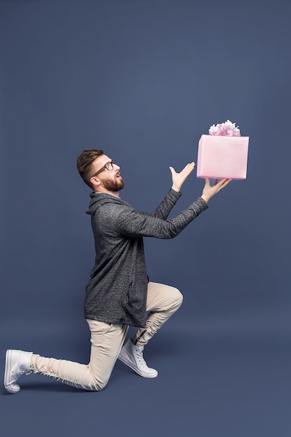 Homme expressif offrant un cadeau emballé