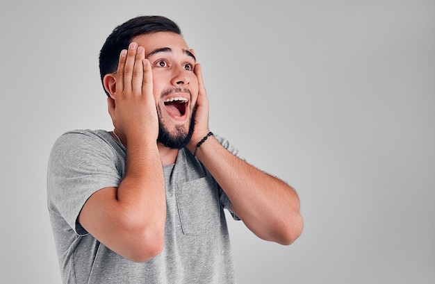 Homme avec une expression choquée et étonnée isolée sur fond gris