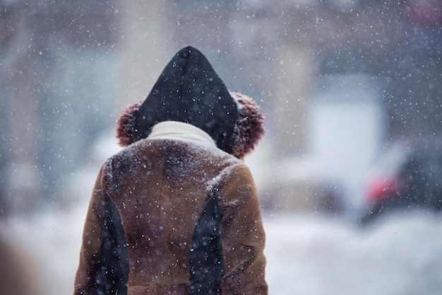 Homme à l'extérieur en vêtements d'hiver pendant le blizzard et les fortes chutes de neige