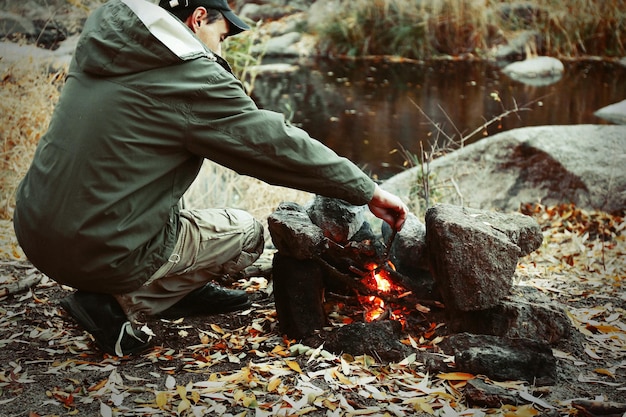 Homme faisant du feu dans les montagnes