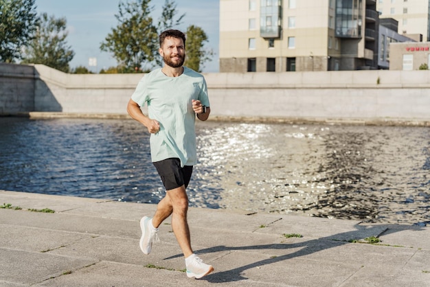 Un homme faisant du jogging au bord de la rivière dans la ville concentré et déterminé