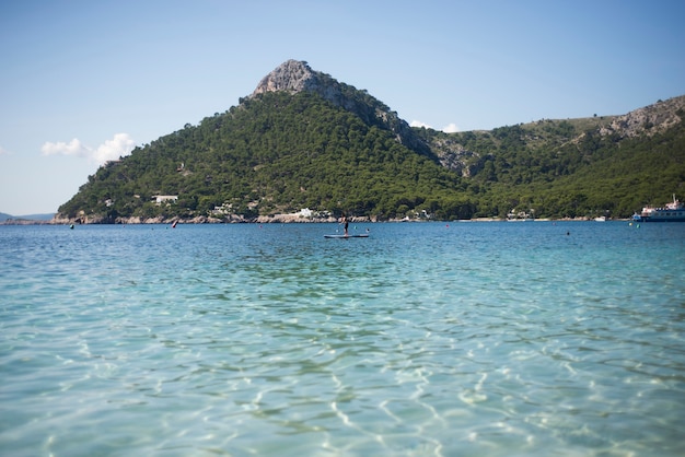 Homme faisant du paddle surf sur une plage paradisiaque en vacances