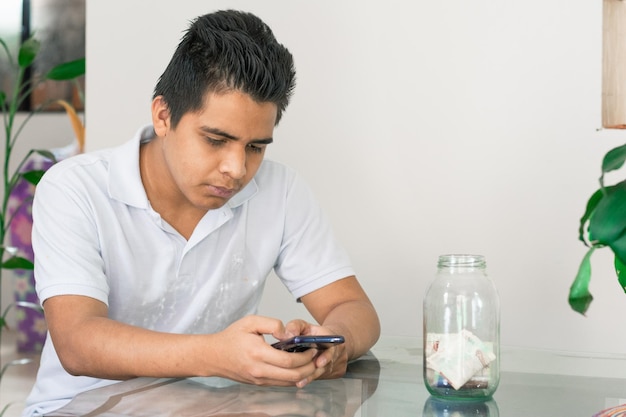 Homme faisant du shopping en ligne, mauvaise situation financière, gars envoyant des SMS sur ses billets de téléphone portable