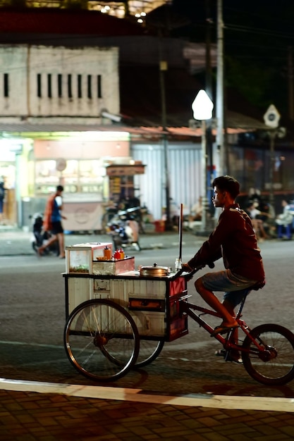 Photo un homme faisant du vélo devant un immeuble