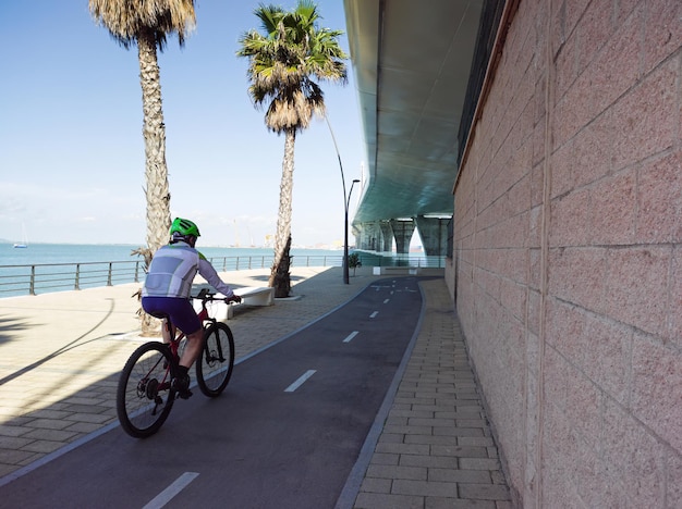 Homme faisant du vélo sur une piste cyclable sur la promenade Mode de vie sain