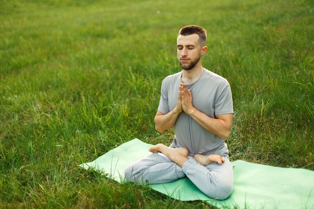 Homme faisant du yoga dans le parc sur la nature. Méditation