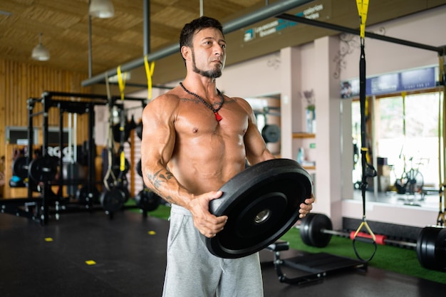 Homme faisant de l'exercice avec un disque de poids