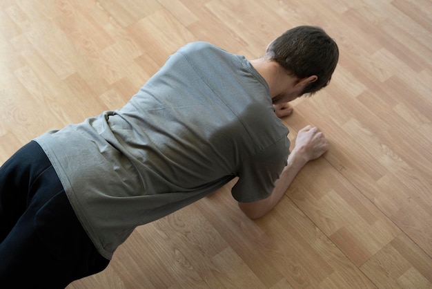 Un homme faisant de l'exercice physique à la maison