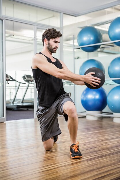 Homme faisant des exercices avec médecine-ball en studio