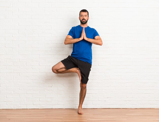 Photo homme faisant des exercices de yoga à l'intérieur