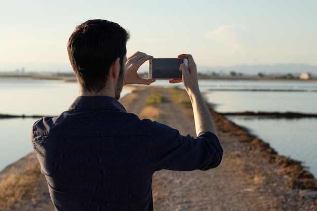 Homme faisant une photo au coucher du soleil