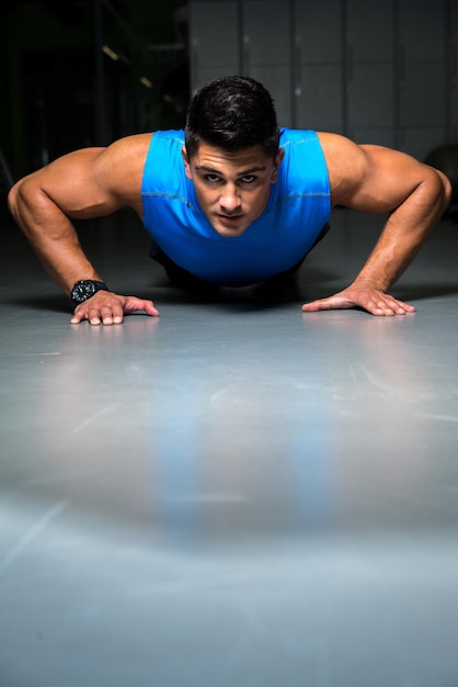 Homme faisant des pompes dans la salle de sport