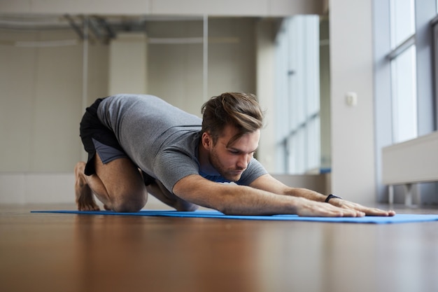 Homme faisant une pose de yoga réparatrice