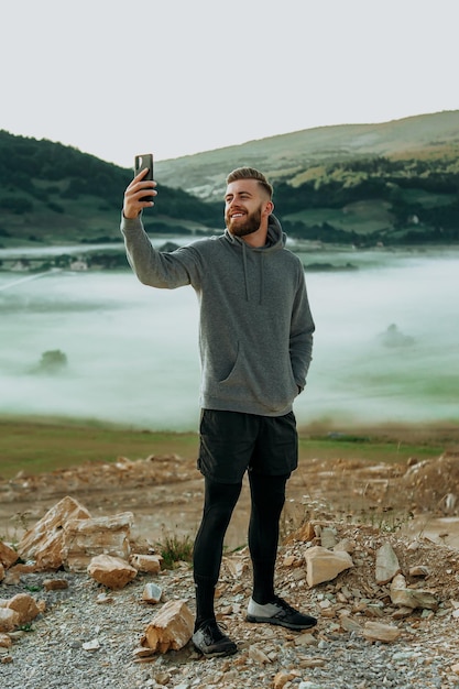 Homme faisant selfie au sommet de la montagne