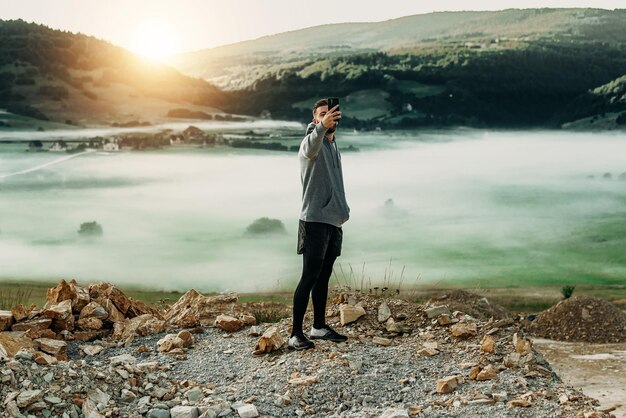 Homme faisant selfie au sommet de la montagne