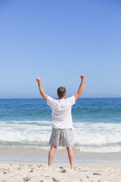 Homme faisant ses étirements sur la plage