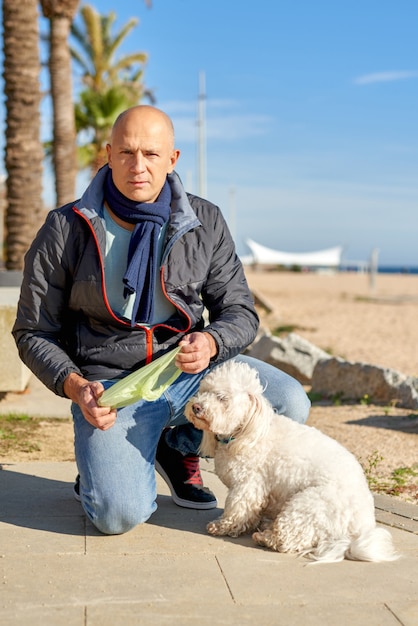 L'homme fait caca dans un sac pour son chien.