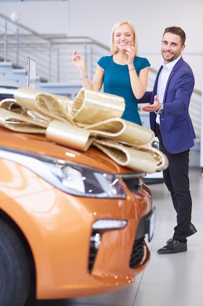 Un homme fait cadeau d'une voiture à sa femme Elle en est surprise Ils en sont très heureux