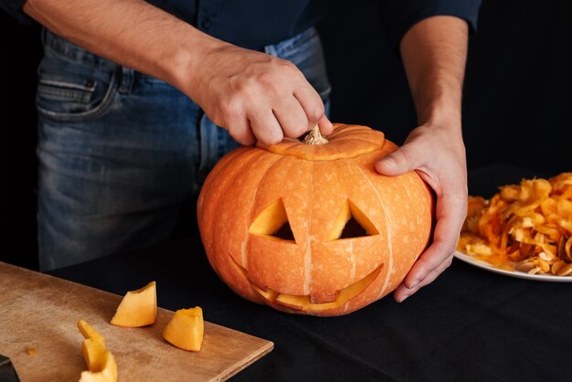 L'homme fait une citrouille orange pour Halloween