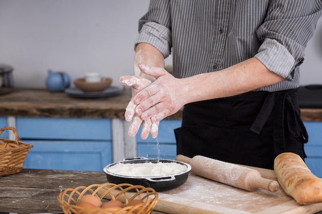 Un homme fait cuire de la farine de pain sur ses mains