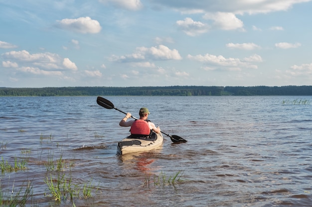 Photo un homme fait du kayak sur une rivière par une belle journée ensoleillée