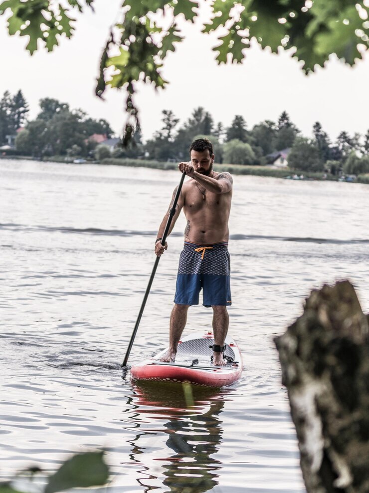 Photo un homme fait du paddleboard dans un lac.