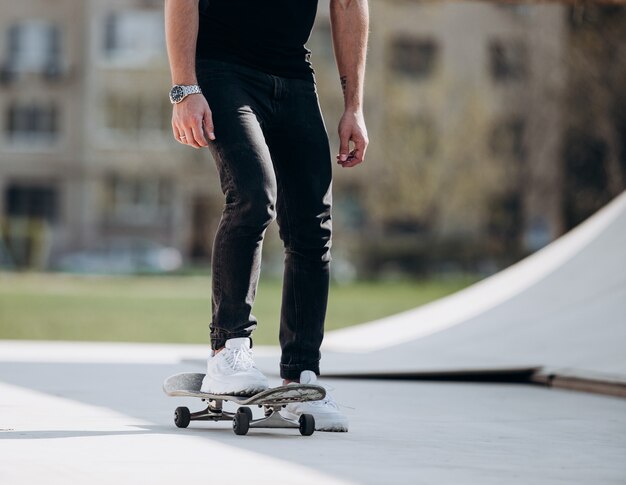 L'homme fait du skateboard sur une plate-forme à l'extérieur à côté de la maison par une chaude journée ensoleillée.