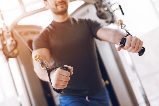 L'homme fait des exercices de force sur un simulateur moderne.