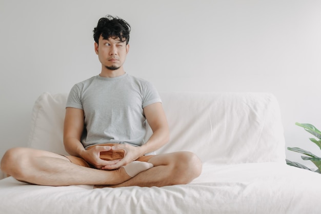 L'homme fait de la méditation sur le canapé avec peu de distraction