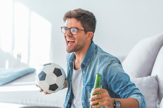 Homme fan fan de football en regardant un match de football à la télévision pour célébrer