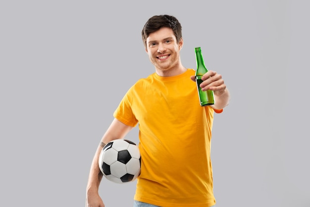 un homme ou un fan de football avec un ballon de football et de la bière