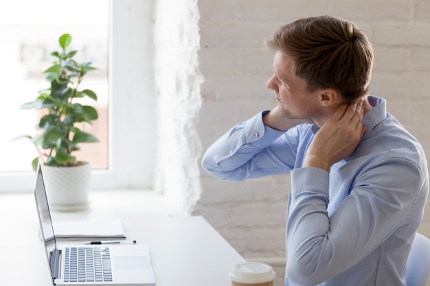 Un homme fatigué du millénaire qui a mal au cou.