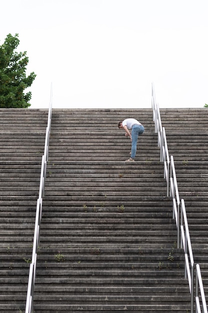 Photo homme fatigué qui monte en haut des escaliers. chemin difficile vers le succès et atteindre le concept d'objectifs