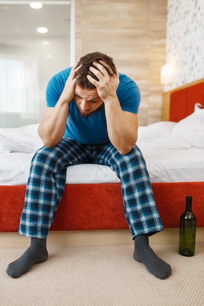 Homme fatigué réveillé dans son lit.