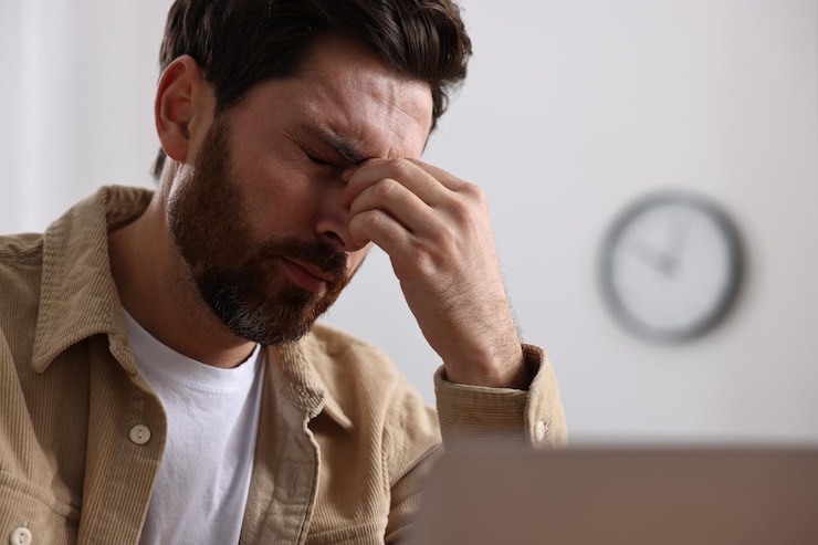 Photo un homme fatigué souffrant de maux de tête au bureau.