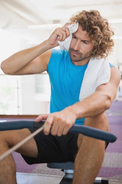 Homme fatigué utilisant la bande de résistance dans la salle de gym