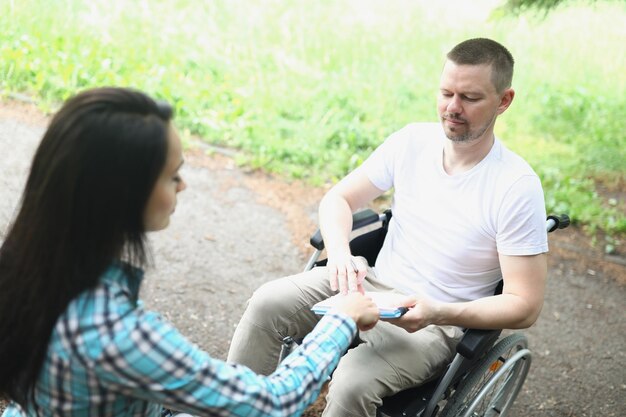 Un homme en fauteuil roulant prend des notes