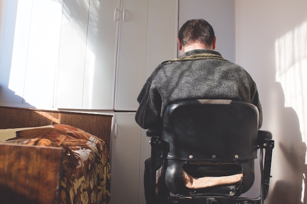 Homme en fauteuil roulant.