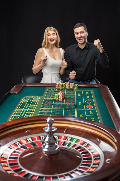 Homme et femme acclamant à la table de roulette au casino