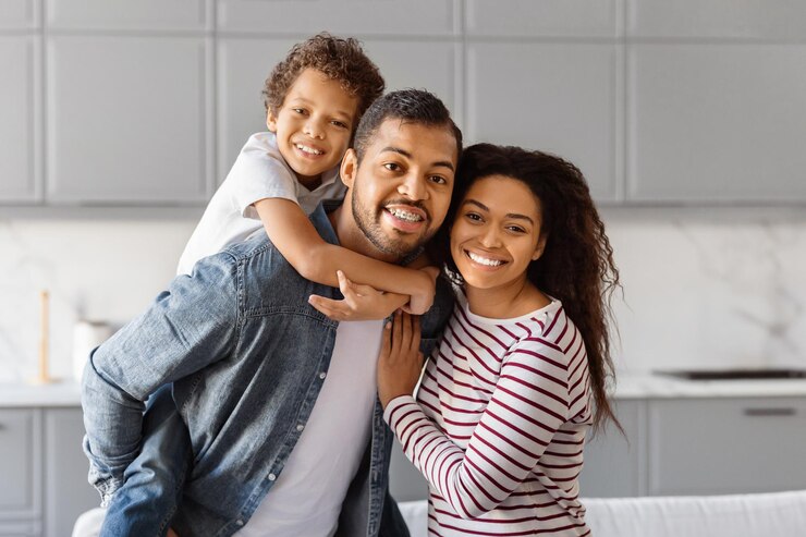 Photo un homme et une femme afro-américains se tiennent dans une cuisine tenant un enfant entre eux, des parents aimants.