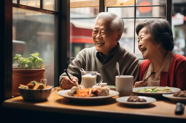 Un homme et une femme âgés asiatiques joyeux déjeunent au café.