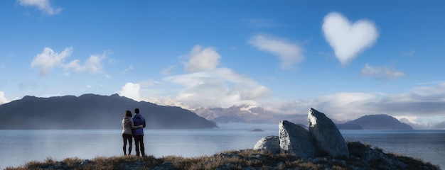 Homme et femme amour couple debout sur la côte rocheuse de l'océan