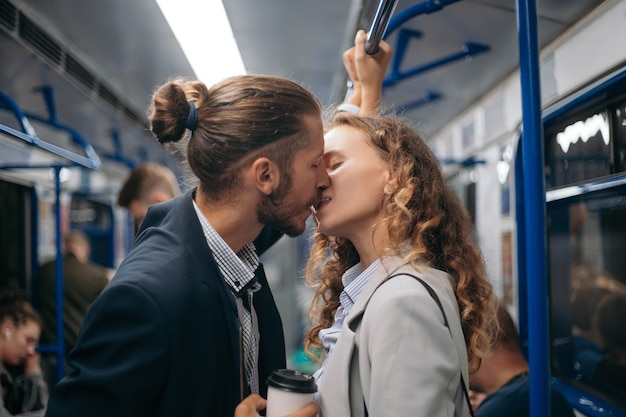 L'homme et une femme amoureuse s'embrassent dans une rame de métro