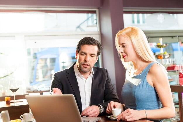 un homme et une femme assis au café